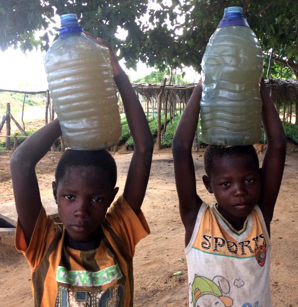 Two boys carrying 10 litre water bottles